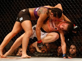 Claudia Gadelha (top) attempts a take down on Joanna Jedrzejczyk in their women's strawweight bout during the UFC Fight Night event at the at U.S. Airways Center on December 13, 2014 in Phoenix, Arizona.  (Christian Petersen/Getty Images/AFP)