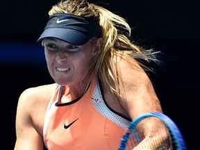 Maria Sharapova of Russia plays a backhand return to Serena Williams of the United States during their quarterfinal match at the Australian Open tennis championships in Melbourne, Australia, Tuesday, Jan. 26, 2016.(AP Photo/Andrew Brownbill)