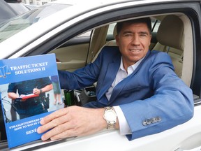 Realtor Rene Papa holds his latest book on how to fight traffic tickets. (Michael Peake/Toronto Sun)