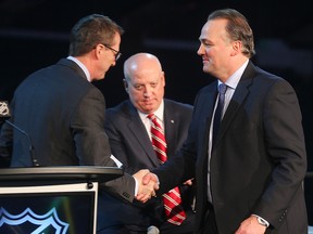 Winnipeg Jets owner Mark Chipman (l) shakes the hand of former Jet Dale Hawerchuk  (r) as NHL Deputy Commissioner Bill Daly looks on at a press conference in Winnipeg, Man. Sunday March 06, 2016 where it was announced that Winnipeg will host the Heritage Classic.
Brian Donogh/Winnipeg Sun/Postmedia Network