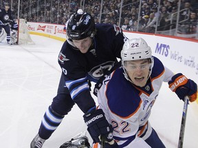 Winnipeg Jets defenceman Jacob Trouba (top) leans into Edmonton Oilers forward Adam Cracknell in Winnipeg last March. Kevin King/Winnipeg Sun/Postmedia Network