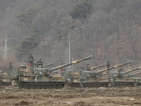 South Korean army soldiers stand on their K-55 self-propelled howitzers during an annual exercise in Paju, near the border with North Korea, Monday, March 7, 2016. North Korea on Monday issued its latest belligerent threat, warning of an indiscriminate "pre-emptive nuclear strike of justice" on Washington and Seoul, this time in reaction to the start of huge U.S.-South Korean military drills. (AP Photo/Ahn Young-joon)