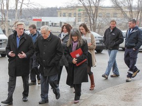 Jim Keech, left, president of Utilities Kingston, walks and talks with Bob Chiarelli, Ontario's energy minister and Kingston and the Islands MPP Sophie Kiwala during the minister's tour of local energy conservation retrofitted Kingston & Frontenac Housing Corporation social housing. Julia McKay/The Whig-Standard)
