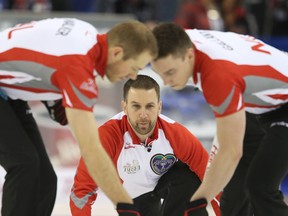 Skip Brad Gushue throws as Geoff Walker (left) and Brett Gallant (right) of Team Newfoundland and Labrador sweep the ice against Team Saskatchewan during the Brier at TD Place in Ottawa on Monday, March 7, 2016. (Jean Levac/Postmedia Network)