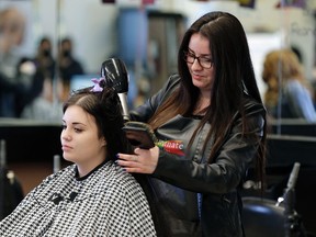 Cosmetology student Paula Sandoval styles the hair of her client Kayla Rachkewich at Archbishop O'Leary High School in Edmonton where they have a program that helps students get the career credits they need without going to college. Grads can go straight into a salon placement, potentially saving thousands of dollars in college tuition. (LARRY WONG/POSTMEDIA)