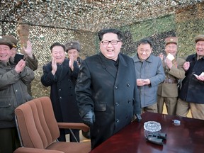 North Korean leader Kim Jong Un smiles as he guides a test fire of a new multiple launch rocket system in this undated photo released by North Korea's Korean Central News Agency in Pyongyang March 4, 2016. (REUTERS/KCNA)