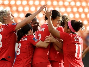 Canada's Christine Sinclair, centre, is congratulated after scoring a goal against Trinidad & Tobago during second-half CONCACAF Olympic qualifying tournament action in Houston on Feb. 14, 2016. (AP Photo/David J. Phillip)