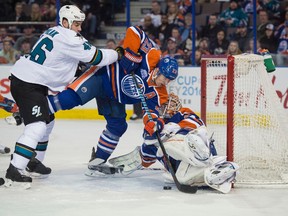 Matt Hendricks tries to help Oilersgoalie Cam Talbot cover up as Roman Polak of the San Jose Sharks rushes the net at Rexall Place on Tuesday. (Shaughn Butts)