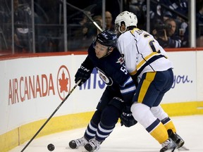 Winnipeg Jets' Marko Dano (56) is pushed into the boards by Nashville Predators' Anthony Bitetto (2) during second period NHL hockey action in Winnipeg on Tuesday, March 8, 2016. THE CANADIAN PRESS/Trevor Hagan