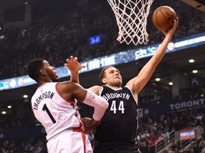 The Brooklyn Nets’ Bojan Bogdanovic puts in a layup against the Raptors’ Jason Thompson on Tuesday night at the Air Canada Centre. Thompson and Norm Powell were inserted into the starting five. (The Canadian Press)