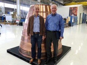 Blue Origin founder Jeff Bezos, left, stands with president Rob Meyerson in front of a copper exhaust nozzle to be used on a space ship engine on the company's research and production floor during a media tour there, Tuesday, March 8, 2016, in Kent, Wash. The private space company opened its doors to the media for the first time on Tuesday to give a glimpse of how organizations like Blue Origin are creating the next generation of rockets for private and public use. (AP Photo/Donna Blankinship)