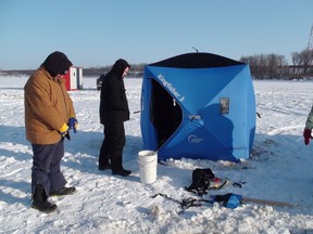 Ice fishermen Steven Brock (left) and Tim Gray prepare to pack up after a day of ice fishing on the Red River near Selkirk.