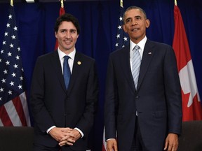 U.S. President Barack Obama and Prime Minister Justin Trudeau stand up following their bilateral meeting at the Asia-Pacific Economic Co-operation summit in Manila, Philippines Nov. 19, 2015. (THE CANADIAN PRESS/AP/Susan Walsh)