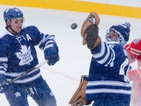 Toronto Maple Leafs goaltender Jonathan Bernier is knocked by Detroit Red Wings defenceman Daniel Cleary as he tries to catch an airborne puck during the NHL Winter Classic at Michigan Stadium in Ann Arbor, Michigan on Wednesday January 1, 2014. (CRAIG GLOVER/Postmedia Network)