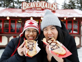 Kay Fung, left, and Gigi Tuet, both from Vancouver, enjoy some BeaverTails while in Ottawa January 28, 2016. BeaverTails is opening a permanent bakery and cafe in Toronto. (Darren Brown/Postmedia Network)