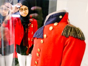 Midhat Naeem, a Grade 8 student at Dr. Roberta Bondar Public School in Ajax, stands next to Sir Isaac Brock's tunic during the school's history fair on Wednesday, March 9, 2016. (Veronica Henri/Toronto Sun)