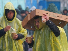 Migrants eat rations of hot soup during a heavy rain storm at the northern Greek border station of Idomeni, Wednesday, March 9, 2016.  Northbound borders are closed and authorities plan to distribute fliers telling refugees seeking to reach central Europe that “there is no hope of you continuing north, therefore come to the camps where we can provide assistance” as more than 36,000 transient migrants are thought to be stuck in financially struggling Greece. (AP Photo/Vadim Ghirda)