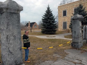 Gino Reale of London stands outside the gate of the former Alma College with the music building and chapel still standing. Reale has purchased the property from the Zubic family of London and intends to begin cleanup of the debris-ridden property this spring.