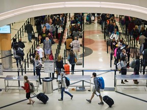 In this Wednesday, Nov. 25, 2015 file photo, travellers wait to go through a security checkpoint at Hartsfield–Jackson Atlanta International Airport, in Atlanta. Officials in Atlanta are laying the groundwork for an expansion of the world's busiest airport. According to a news release from the Metro Atlanta Chamber, work will begin soon on a $6 billion expansion and renovation project at the airport. (AP Photo/David Goldman, File)