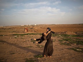 Syrian refugee girls, Ayat Mahmoud, 16, and Farah Ali, 5, plays at an informal tented settlement near the Syrian border on the outskirts of Mafraq, Jordan, Friday, Jan. 22, 2016. (AP Photo/Muhammed Muheisen)