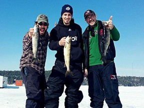 Sudbury Wolves captain Danny Desrochers (centre) poses with a lake trout with Scott Haddow (left) and Bruce Heidman.