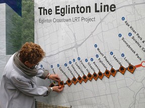 Ontario Premier Kathleen Wynne places a hard hat sticker on a map of the Eglinton Crosstown at the site of Keelesdale Station, at Keele and Eglinton, where construction is underway. (Michael Peake/Toronto Sun/Postmedia Network)