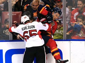 Ottawa Senators defenseman Erik Karlsson checks Florida Panthers centre Jonathan Huberdeau  into the boards on March 10. (USA Today Sports)