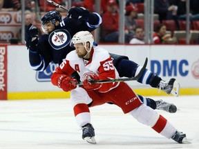 Winnipeg Jets' Blake Wheeler (26) is tripped up by Detroit Red Wings' Niklas Kronwall (55), of Sweden, during the third period of an NHL hockey game Thursday, March 10, 2016, in Detroit. The Red Wings defeated the Jets 3-2. (AP Photo/Duane Burleson)