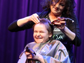 Sudbury Secondary School student Cassidy Barrett holds what's left of her long hair while getting her head shaved during a school fundraiser at Sudbury Secondary on Thursday. Two teachers and six students had their hair cut or shaved to be donated and to show support for Vicki Ashick, a teacher recently diagnosed with breast cancer. Ben Leeson/The Sudbury Star/Postmedia Network