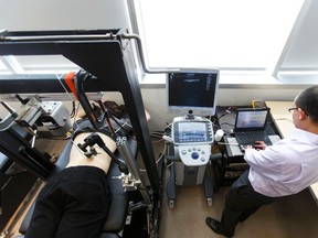 Lead engineer Anthony Au (right) demonstrates a vibration test during a press conference at the Edmonton Clinic Health Academy at the University of Alberta in Edmonton, Alta., on Thursday March 10, 2016. Using an identical twin study from the University of Southern Denmark, the team shows that structural changes within the spine alter its vibration response significantly. Their research is being published online in Nature: Scientific Reports. Photo by Ian Kucerak