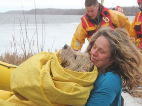 Harriet Richardson carries her dog Colby after he was rescued from the ice by firefighters in Kingston, Ont. on Friday, March 11, 2016...Michael Lea The Whig-Standard Postmedia Network