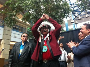 Joseph Meconse raises his hand in triumph flanked by Manitoba Deputy Premier Eric Robinson (left) and Assembly of First Nations grand chief Perry Bellegrande following a press conference at Portage Place mall in Winnipeg on Friday, March 11, 2016. Portage Place announced a series of significant changes including the appointment of Meconse as its official Ogichidaa, an indigenous ambassador and liaison and the hiring of a native security firm for the mall. In late January, the Dene elder and decorated military veteran was kicked out of the downtown mall's food court for loitering after he had just sat down with a plate of food.