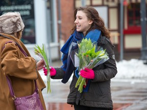 Karyn Hill hands out tulips on the Byward Market as retailer Nordstrom's Rideau Centre has a crew of three driving around town this week in a colourful panel van handing out 500 bouquet's of tulips each day to bring a little spring cheer into pedestrians lives in Ottawa. WAYNE CUDDINGTON/POSTMEDIA