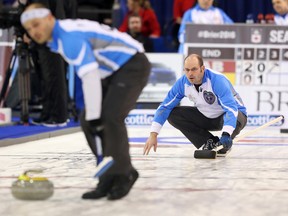 Skip Jean-Michel Ménard (R) of Team Quebec throws his stone as it is swept by Philippe Ménard (L) of Team Quebec against Team Alberta during the Tim Hortons Brier held at TD Place in Ottawa, March 08, 2016. (Jean Levac)