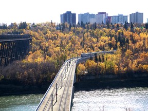 Fall colours line the southside of the North Sasskatchewan River with the High Level Bridge on the left as an LRT car crosses the Dudley B. Menzies Bridge in Edmonton, Alta on Tuesday Oct 6, 2015. Hugo Sanchez/Edmonton Sun