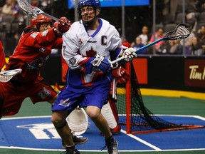 Colin Doyle of the Rocks (right) is hammered by the Roughnecks’ Scott Carnegie in the third quarter at the Air Canada Centre last night. (Jack Boland/Toronto Sun)