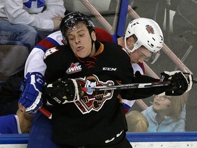 Calgary Hitmen's Beck Malenstyn smooshes Edmonton Oil Kings' Brayden Gorda into the boards on the way to a 5-0 Calgary shutout at Rexall Place on Friday. (LARRY WONG)
