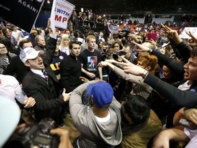 Supporters of Republican presidential candidate Donald Trump, left, face off with protesters after a rally on the campus of the University of Illinois-Chicago was cancelled due to security concerns Friday, March 11, 2016, in Chicago. (AP Photo/Charles Rex Arbogast)