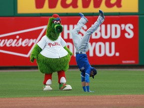 Toronto Blue Jays right fielder Jose Bautista does a hand stand as he goofs off with Philadelphia Phillies mascot Phillie Phanatic, before the game at Bright House Field. (Kim Klement/USA TODAY Sports)