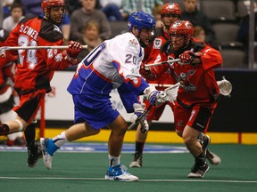 Toronto Rock Bradley Kri is checked  by Calgary Roughnecks Tyler Burton in the fourth quarter during the National Lacrosse League action at the ACC in Toronto, Ont. on Friday March 11, 2016. (Jack Boland/Toronto Sun/Postmedia Network)