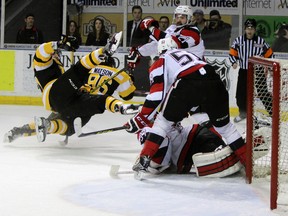 Kingston Frontenacs Stephen Desrocher and Spencer Watson take a tumble in front of Ottawa 67's goalie Leo Lazarev in the second period of Ontario Hockey League action at the Rogers KRock Centre in Kingston, Ont. on Saturday March 12, 2016. The 67's defeated the Fronts 5-4 in overtime. Steph Crosier/Kingston Whig-Standard/Postmedia Network