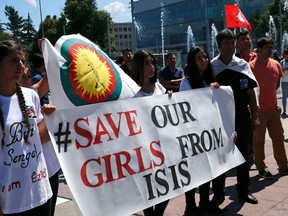 Women hold a banner during a demonstration marking the first anniversary of Islamic State's surge on Yazidis of the town of Sinjar, in front of the United Nations European headquarters in Geneva, Switzerland, August 3, 2015. (REUTERS/Denis Balibouse)