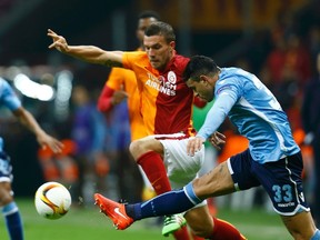 Galatasaray's Lukas Podolski and Lazio's Mauricio in action.   REUTERS/Osman Orsal
