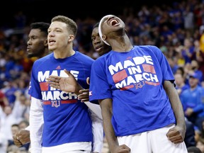 Top-ranked Kansas players celebrate a victory over West Virginia in the Big 12 conference finals on Saturday. (The Associated Press)