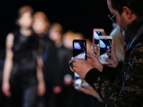 Guests film models with their smart phones during the Costume National women's Fall-Winter 2016-2017 collection, part of the Milan Fashion Week, unveiled in Milan, Italy, Thursday, Feb. 25, 2016.Long gone are the days when fashion week attendees relied solely on notepad scribbles to document the finer points of new designs. But even as tech tools help streamline the way in which images from runway shows are captured and distributed, one fashion label recently opted to dial back the digital clock. THE CANADIAN PRESS/AP/Luca Bruno