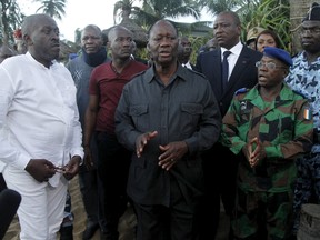 Ivory Coast's President Alassane Ouattara speaks as he stands between hotel manager Mr. Able and Ivory Coast's army chief Soumaila Bakayoko at the hotel Etoile du Sud in Grand Bassam, Ivory Coast, on March 13, 2016. (REUTERS/Luc Gnago)