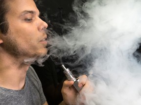 Mike Livingston, an employee at 180 Smoke, blows out vapour from an e-juice cigarette on June 19, 2015. (Craig Robertson/Toronto Sun files)
