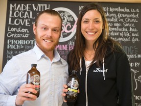 Booch owners Shawn Slade and Shannon Kamins display two bottles of their fermented tea product, a natural beverage with good-for-the-gut probiotics, in their Dundas Street production facility. The pair plan to renovate the site and turn it into a retail outlet, where their product can be sampled and purchased. (CRAIG GLOVER, The London Free Press)