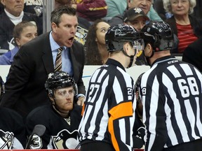 Pittsburgh Penguins head coach Mike Sullivan (L rear) reacts at referee Eric Furlatt (27) and linesman Scott Driscoll (68) after defenceman Kris Letang (not pictured) was penalized for using an illegal stick against the Tampa Bay Lightning during the third period at the CONSOL Energy Center. Tampa Bay won 4-2. Charles LeClaire-USA TODAY Sports