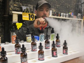 Martin Lacombe demonstrates the use of an e-cigarette inside his downtown Sarnia vape shop and lounge Monday. Lacombe, who runs Tugboat Vaping Co., is concerned about the Ontario government's plan to ban vaping inside enclosed public spaces, including vape shops. (Barbara Simpson, The Observer)
